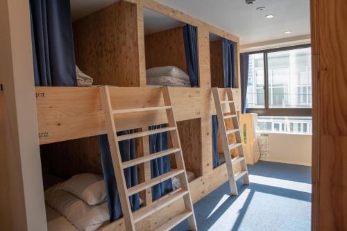 a bunk bed in a room with twoadders at Guesthouse Akicafe Inn in Hiroshima