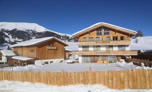 a wooden house with a fence in the snow at Arvenhof in Serfaus