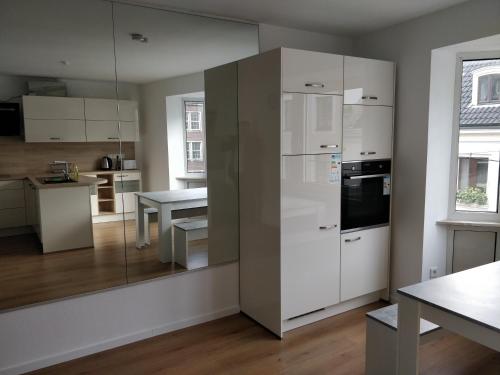 a kitchen with a large white refrigerator and a table at XXL Superior Old Town Apartment in Düsseldorf