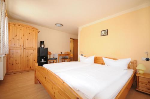 a bedroom with a large bed with white sheets at Pension Klette in Kurort Oybin
