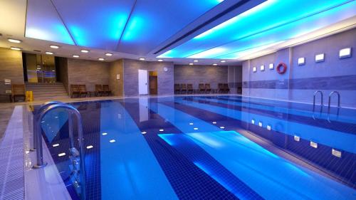 a large swimming pool with blue lights in a building at Point Hotel Taksim in Istanbul