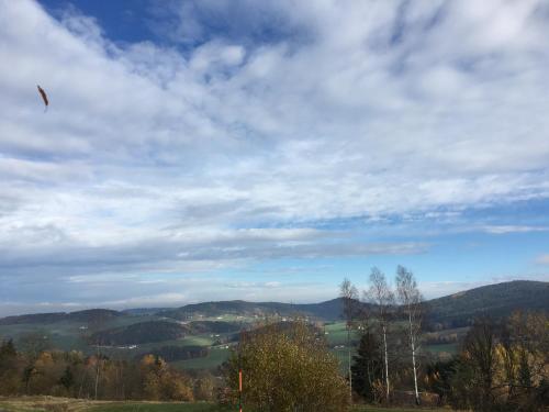 a kite flying in the sky over a valley at Ferienhaus am Kagerstein in Neukirchen beim Heiligen Blut