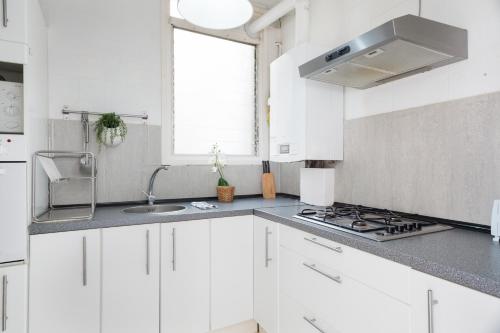 a white kitchen with a sink and a stove at SANTS STATION PENTHOUSE in Barcelona