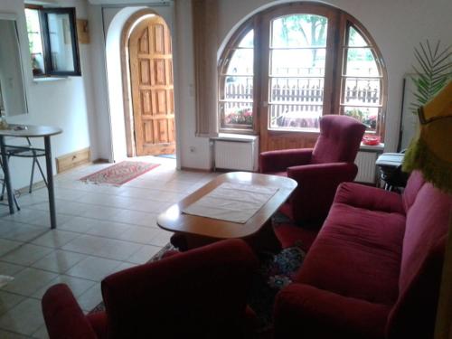 コウォブジェクにあるMieszkanie na wakacjeのリビングルーム(赤い椅子、テーブル付)