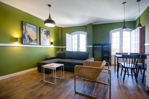 a living room with a couch and a table and chairs at Apartamentos Suites Roma in Merida