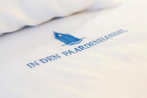 a white shirt with a blue bird on it at In den Paardenhandel te Lampernisse in Diksmuide