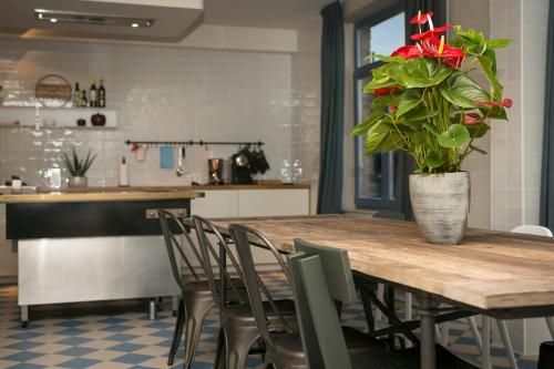 a dining room table with a vase of roses on it at In den Paardenhandel te Lampernisse in Diksmuide