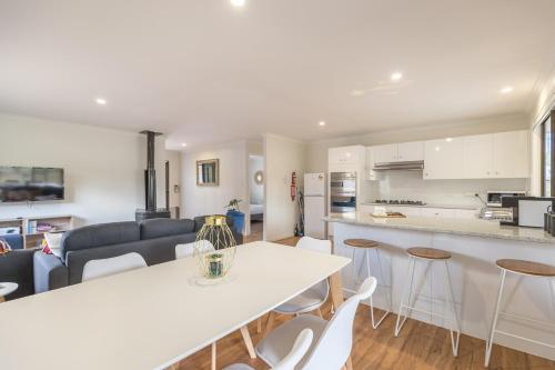 a kitchen and living room with a white table and chairs at Briar Rose Cottages in Stanthorpe