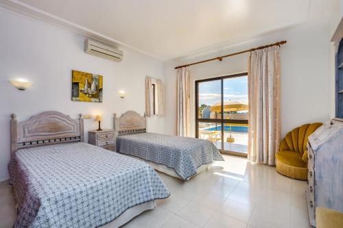 1 Schlafzimmer mit 2 Betten und einem Fenster in der Unterkunft Villa Mirante in Albufeira