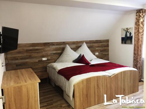una camera da letto con un letto con un tocco di legno di Hotel Schurwald a Rechberghausen