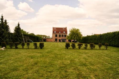 a field with trees in front of a house at Chambres d'Hôtes La Parenthèse in Wambrechies