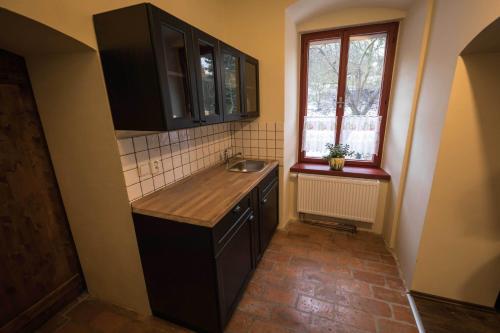 a small kitchen with a sink and a window at Statek Jakubov in Vojkovice