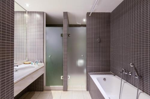 a bathroom with a tub and a sink and a shower at Cabo Verde Hotel in Mati