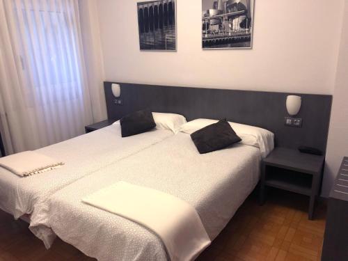 a bedroom with a large bed with two pillows on it at Hotel Ripa in Bilbao