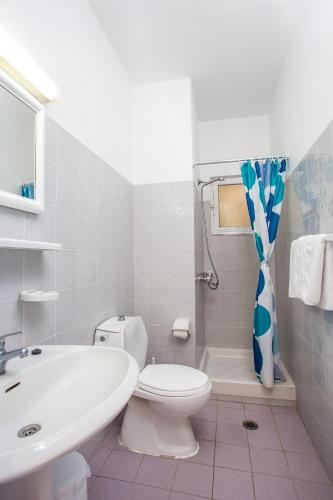 a white bathroom with a toilet and a sink at Irinna Hotel-Apartments in Faliraki