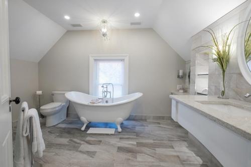 a white bathroom with a tub and a toilet at The Victorian Luxury Suites in Westport