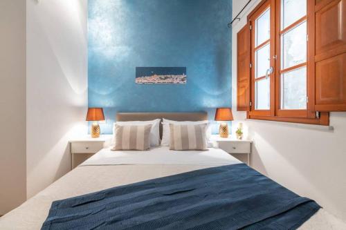 sypialnia z dużym łóżkiem i niebieską ścianą w obiekcie Mirtì boutique Apartment heart Cagliari w Cagliari