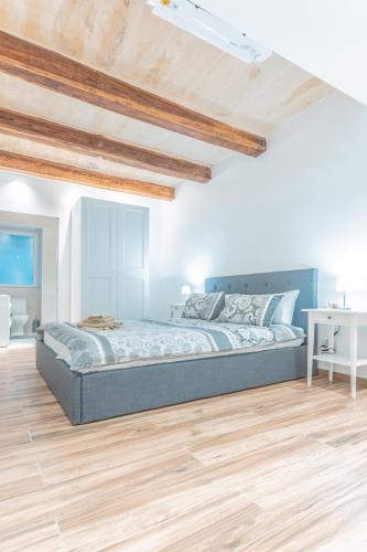 a bedroom with a bed and a wooden floor at Gunpost Suite in Valletta