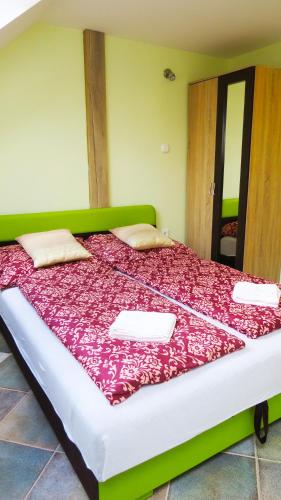 a bedroom with a large bed with a red blanket at Hőforrás Wellness Vendégház in Egerszalók