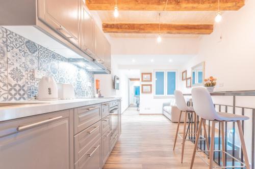 a kitchen with white cabinets and bar stools at Gunpost Suite in Valletta