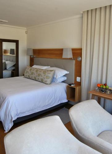 a hotel room with two beds and a chair at Oceans Guest House & Luxurious Apartments in Struisbaai