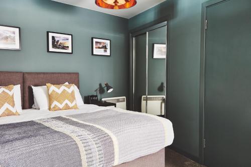 um quarto com uma cama grande e paredes azuis em The Ranald Apartments em Oban