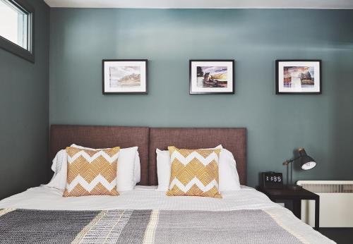 a bedroom with a bed with three pictures on the wall at The Ranald Apartments in Oban