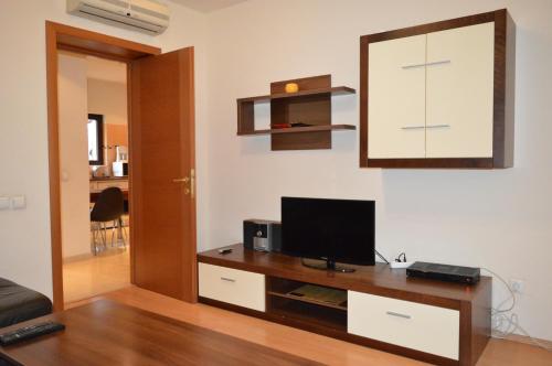 a living room with a television on a wooden table at GrandVille Apartments in Bucharest