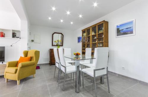 ein Esszimmer mit einem Glastisch und Stühlen in der Unterkunft Apartment Assimetric - Only 100m to Beach in Alcúdia