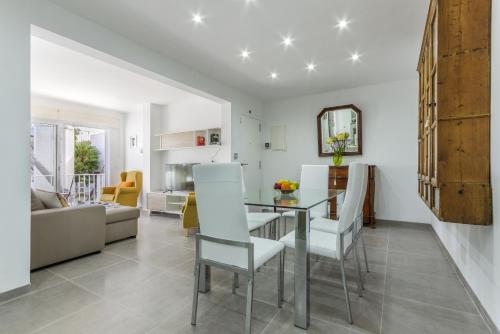 a dining room and living room with a table and chairs at Apartment Assimetric - Only 100m to Beach in Alcudia