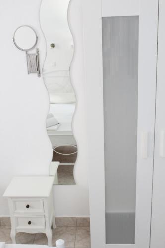 a white room with a mirror and a white dresser at Blue Horizon Ios in Ios Chora