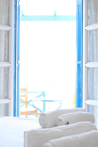 a room with a window with towels on a bed at Blue Horizon Ios in Ios Chora