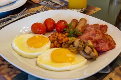 a plate of food with eggs sausage beans and tomatoes at Hoyohoyo Chartwell Lodge in Johannesburg