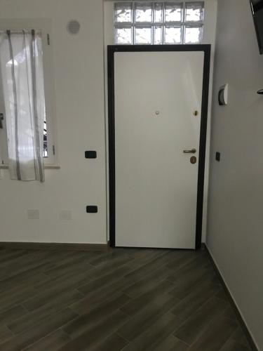 a white door in a room with a wooden floor at La Terrazza sul Mare in Palmi