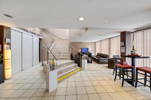 a lobby with a staircase and a couch at HOTEL RESTAURANT PARIS PACIFIC PARIS-VILLEJUIF- PRES DU METRO L'HAY LES ROSES LIGNE 14 - Direct PARIS-AEROPORT ORLY ET INSTITUT GUSTAVE ROUSSI in Villejuif