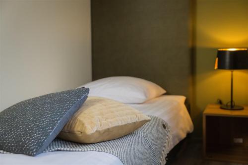 a bedroom with a bed with a pillow and a lamp at Bed & Breakfast Van Marion in Oostvoorne