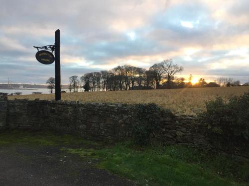 a stone wall with a clock on top of it at Redington House SelfCatering accommodation in Cobh