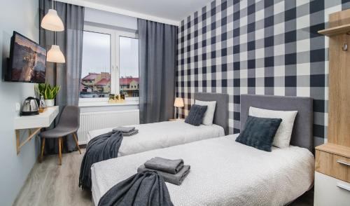 una camera d'albergo con due letti e una finestra di Królewiecka 115 a Elblag