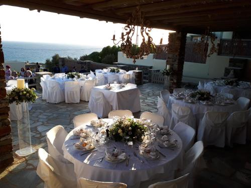 a group of tables with white table cloths and flowers at Diles & Rinies in Tinos Town
