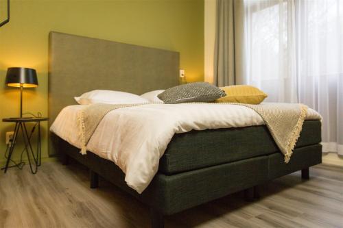 a bedroom with a large bed with a large headboard at Bed & Breakfast Van Marion in Oostvoorne