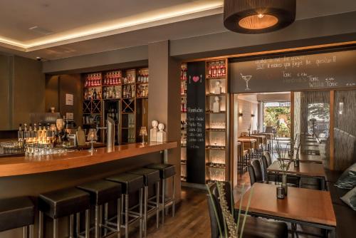 a bar with leather stools and a counter in a restaurant at Bavaria Boutique Hotel in Munich