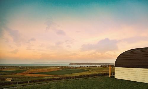 a view of the countryside from a barn at sunset at Braeside Retreats in Thurso