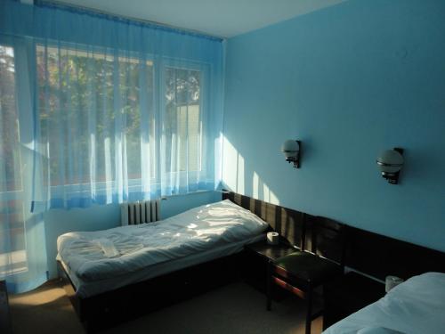 Habitación azul con cama y ventana en Балнеохотел "Свети Мина", en Vetren
