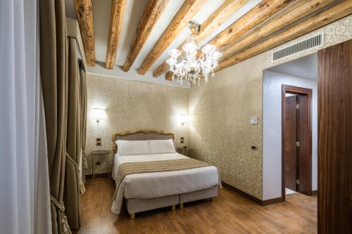 a bedroom with a bed and a chandelier at Palazzo San Lorenzo in Venice