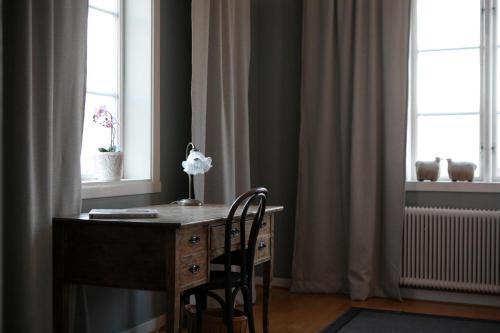 uma secretária com uma cadeira e uma flor numa sala em Slottsparken Motel em Huskvarna