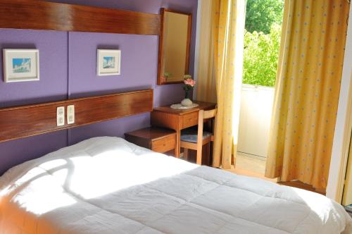 1 dormitorio con cama blanca y espejo en Residencial Moderna, en Figueira da Foz