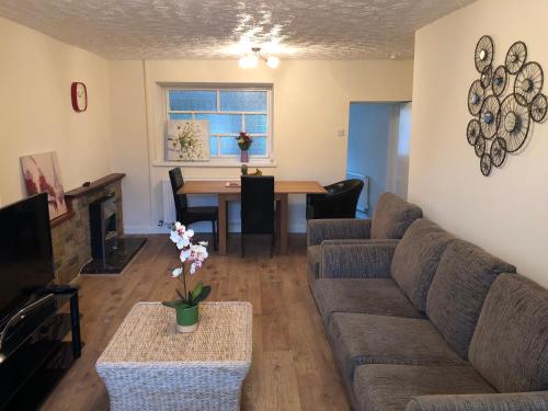 a living room with a couch and a table at 11 Llainwen Isaf in Llanberis