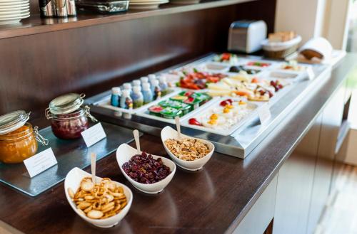 a counter topped with lots of different types of food at Adele Boutique Hotel in Pécs