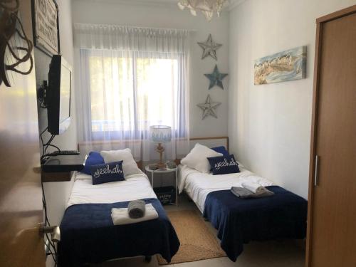 1 dormitorio con 2 camas, TV y estrellas en la pared en Alicante hills - apartment Gilda, en Alicante