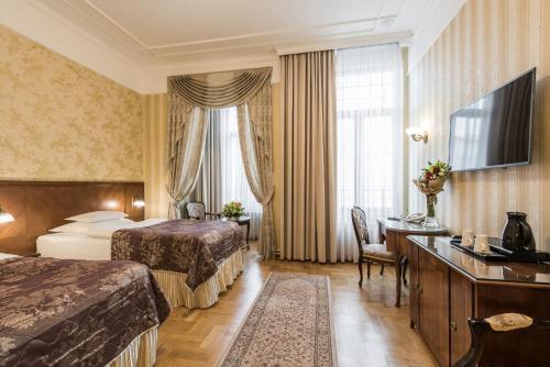 a hotel room with two beds and a desk at Hotel Moskva in Belgrade
